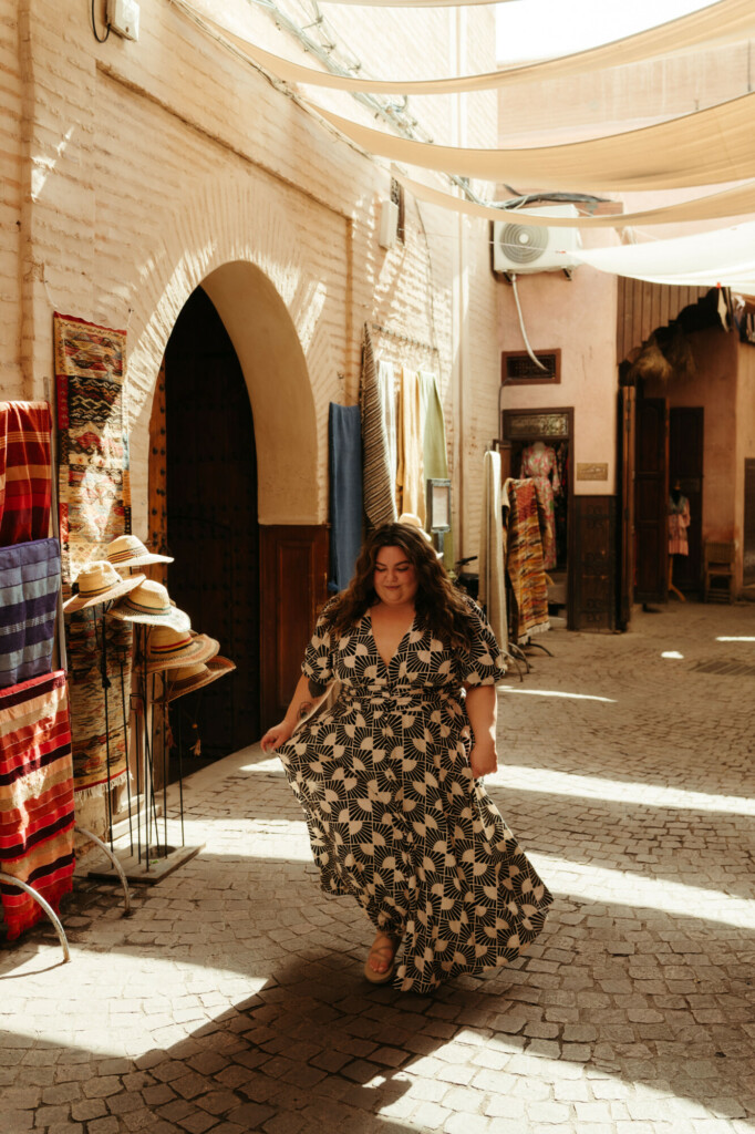 plus size woman walking through the medina in Marrakech, Morocco wearing a loose flowy dress