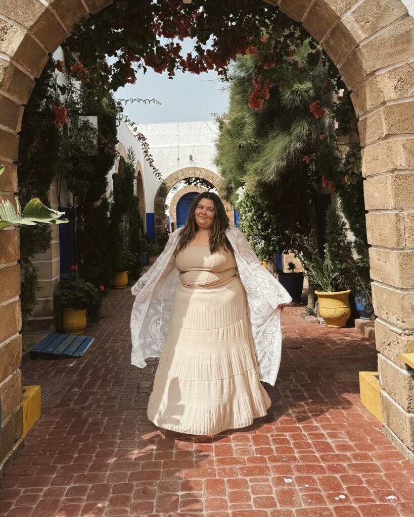 plus size woman walking through Essaouira, Morocco wearing a crochet kimono and a flowy maxi skirt